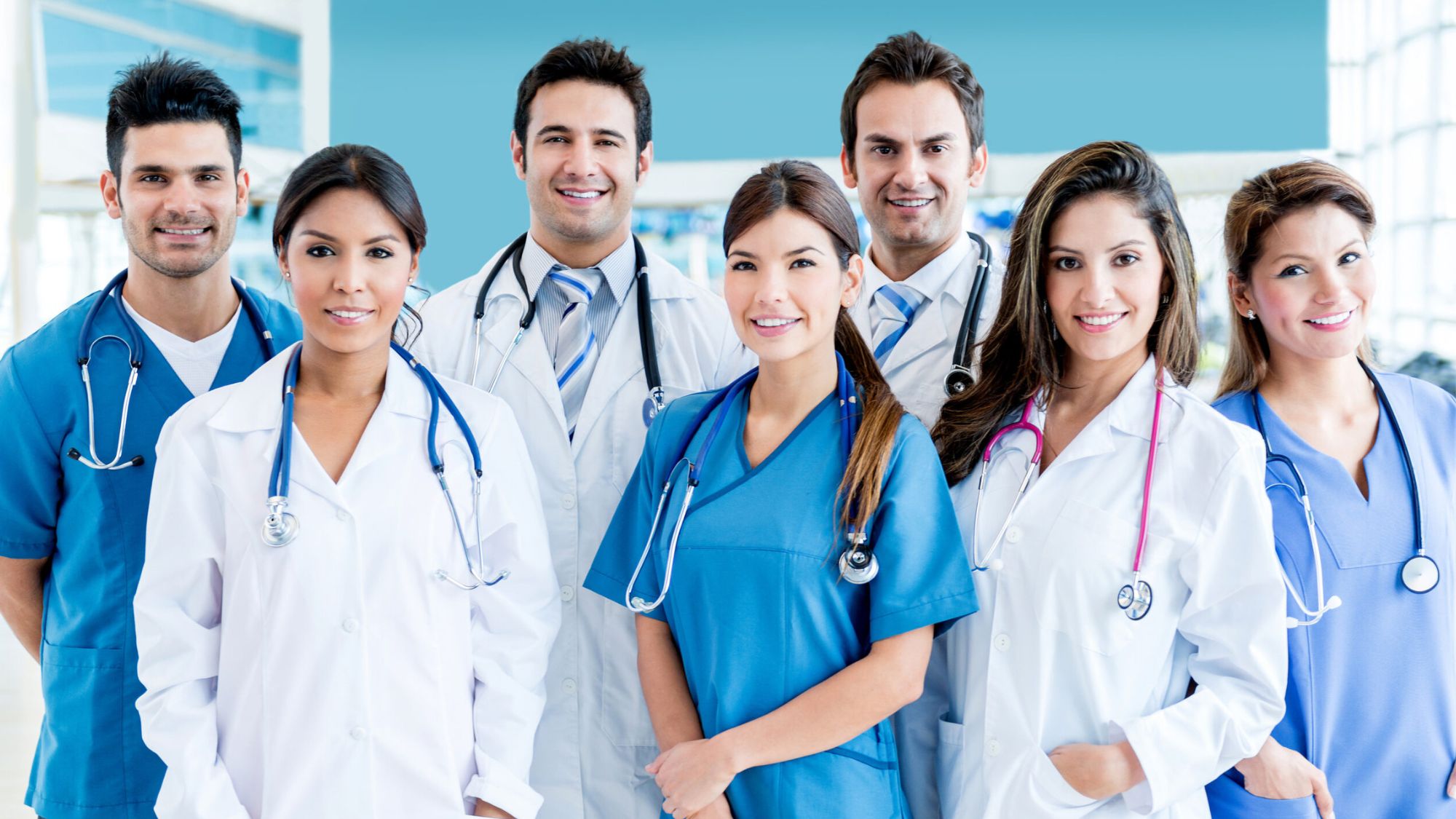 A group of doctors wearing medical apparel (scrubs) smiling